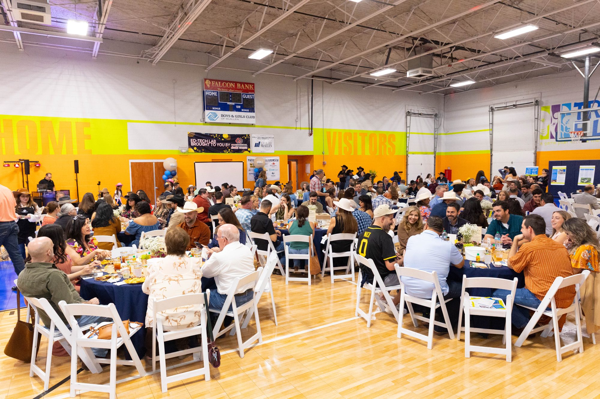 A packed dining hall at a Noble Charities community fundraiser in a school gymnasium