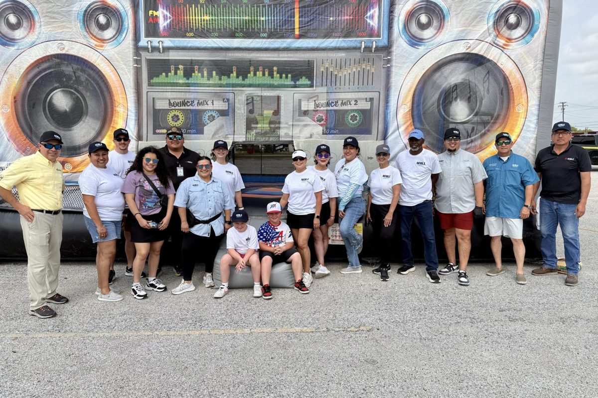 Attendees lined up for a group photo in front of the block party sound stage